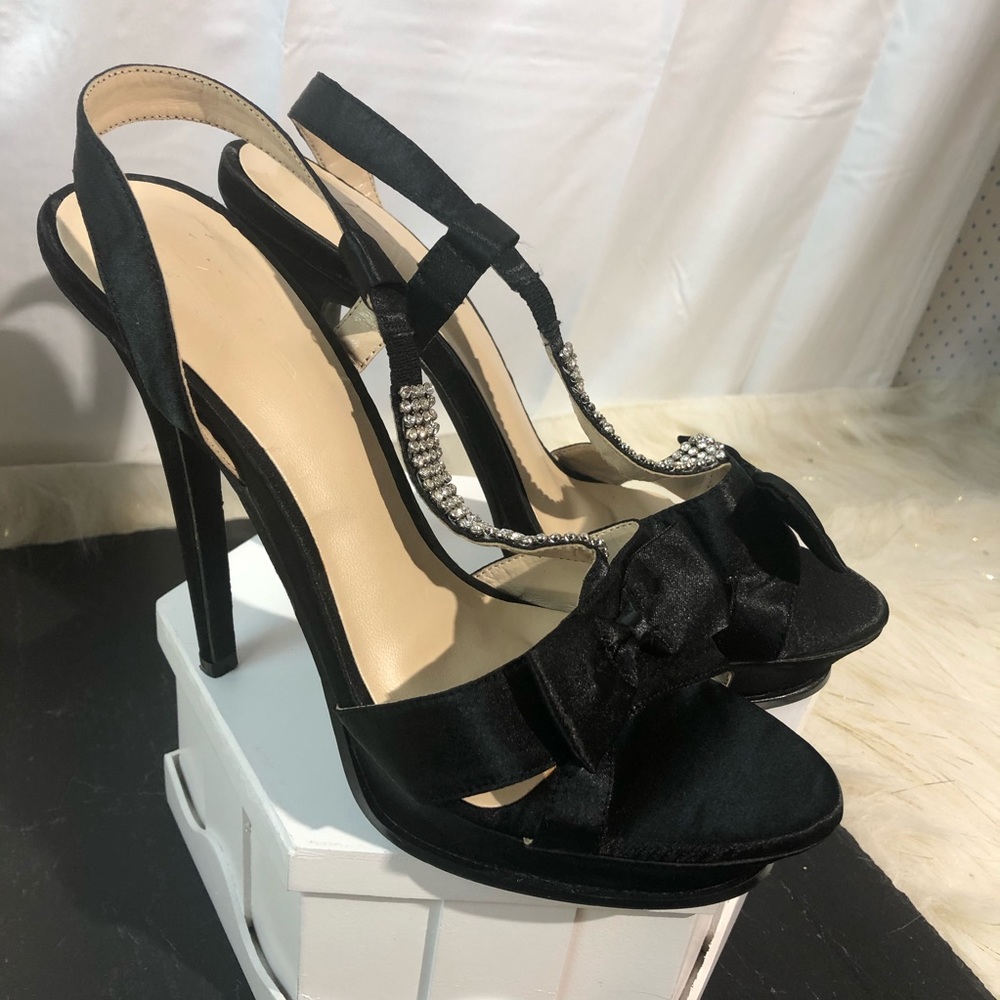 Black satin heels with rhinestone and bow accents.